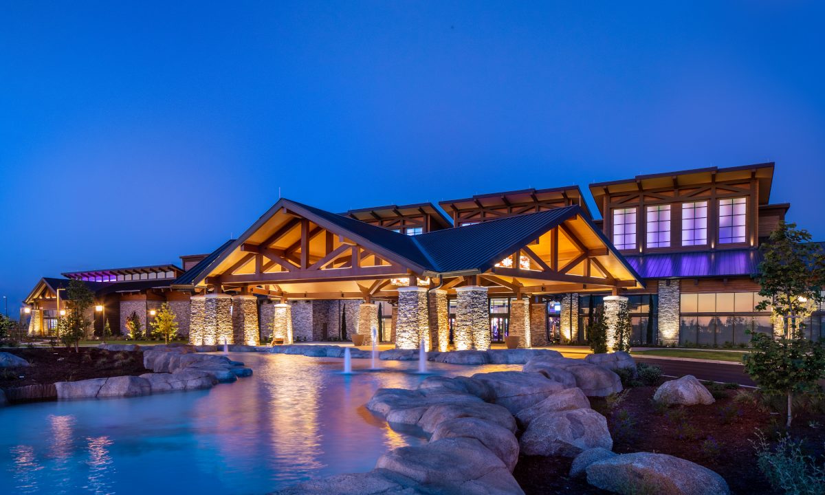 exterior of a contemporary Craftsman styled building, colorfully lit at twilight
